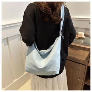 Close-up of a light blue nylon cloud tote bag showing soft texture and pleated design
