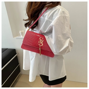 Detail of red crocodile texture shoulder bag with gold S-buckle and elegant metal tassel
