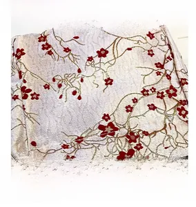 Detail shot of vintage jacquard fabric with red floral pattern and golden silk texture