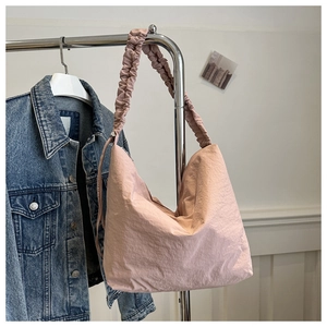 Detail of pink nylon cloud tote bag featuring scrunchie style ruched shoulder straps