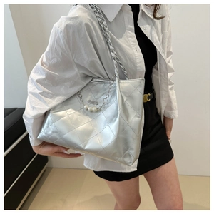 Close-up of silver quilted tote bag with metallic leather and pearl chain strap