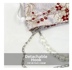 Detail of detachable hook and pearl strap on floral jacquard shoulder bag with drawstring