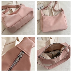 Detail view of pink nylon shoulder bag featuring large capacity and silver metal hardware