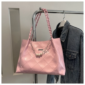 Detail of pink quilted tote bag with pearl chain decoration and woven handles