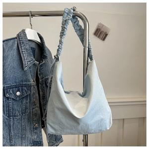 Detail of light blue nylon hobo bag with a soft ruched scrunchie shoulder strap design