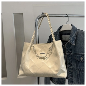 Detail of cream white quilted tote bag with pearl flower chain and woven handles