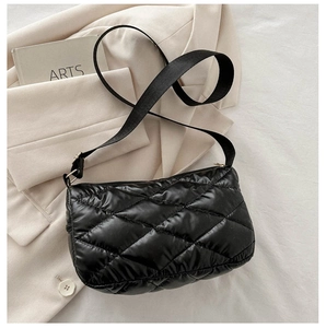 Détail du sac à bandoulière noir matelassé avec surpiqûres et sangle ajustable