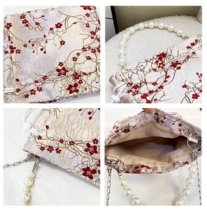 Detail view of jacquard pattern with plum blossom embroidery and pearl handle