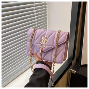 Detail of lavender quilted crossbody bag with golden V-stitching and S-logo buckle