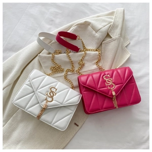Detail of quilted white and magenta crossbody bags with gold S-buckle and chain strap
