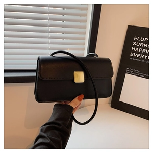 Dettaglio di una borsa in pelle nera opaca con una chiusura in metallo dorato di alta qualità