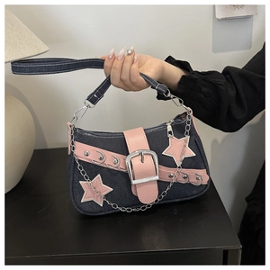 Detail of blue denim shoulder bag with pink leather stars and silver chain accents