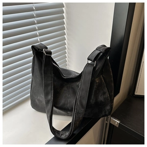 Detail of black crossbody bag with matte washed texture and adjustable wide strap