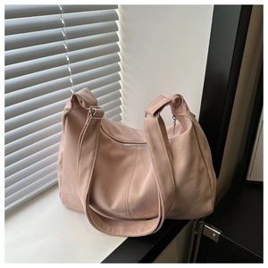 Pink nylon crossbody dumpling bag with wide shoulder strap and silver zipper detail