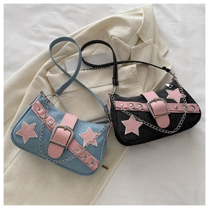 Detail of denim shoulder bags with pink leather accents and silver star patchwork