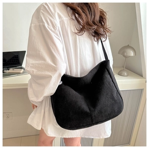 Detailed view of the black corduroy shoulder bag showing texture and large capacity size