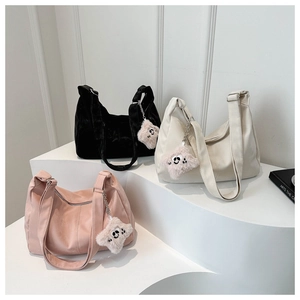 Three minimalist hobo bags in black, beige and pink with plush star charms on display
