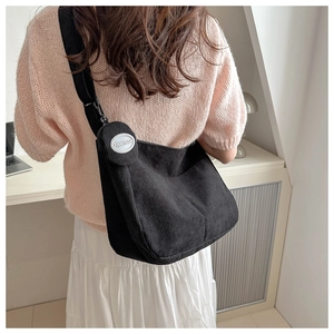 Close-up of black corduroy crossbody bag with a round FANYISSA brand coin purse