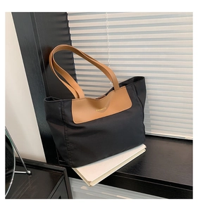 Detail of contrast stitch PU tote bag with FASHION embossed logo in home setting