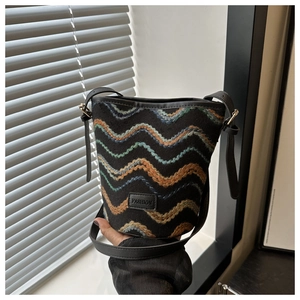 Detail of woven wave embroidery and fashion leather patch on bucket bag texture