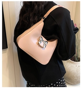 Detail view of a pink bow shoulder bag with silver metal accent on high-quality synthetic leather