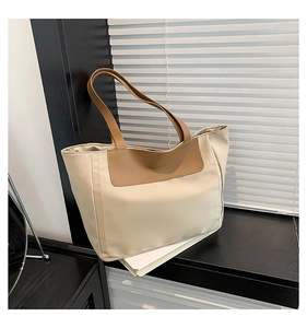Detail of the 'FASHION' embossed leather flap on a beige contrast tote bag