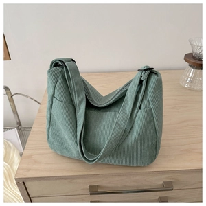 Detailed close-up of mint green corduroy tote bag featuring soft texture and side pocket