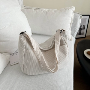 Dettaglio della borsa tote in velluto a coste beige con trama e tracolla larga