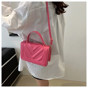 Borsa a tracolla quadrata rosa acceso con trapuntatura a V mostrata sulla modella