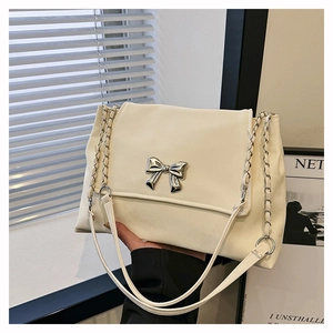Detailed macro view of an off-white shoulder bag featuring a silver metal bow buckle