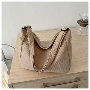 Detailed close-up of beige corduroy shoulder bag showing texture and adjustable strap