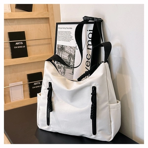 Detailed view of white nylon crossbody bag with black drawstring zipper details