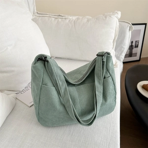 Dettaglio della borsa tote in velluto a coste verde salvia con cerniera e tasche laterali