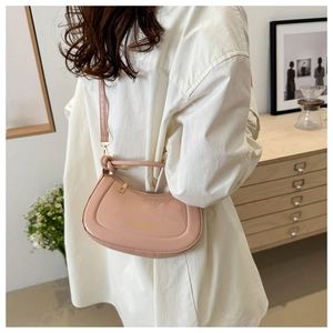Chic light pink semi-circular PU leather shoulder bag with gold text and knot strap detail