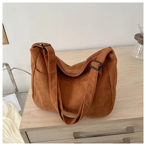 Detailed close-up of warm brown corduroy hobo bag featuring striped texture and side pocket