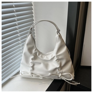 Dettaglio della borsa tote bianca con pieghe verticali e fiocco decorativo in morbida pelle