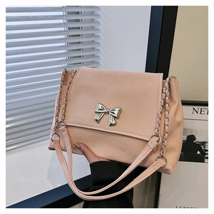 Detailed view of pink bucket bag with silver metal bow and matte suede texture finish
