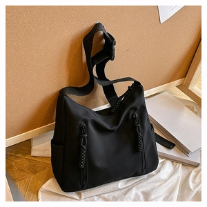 Detail view of black nylon hobo bag featuring parallel vertical zipper pockets with woven pulls