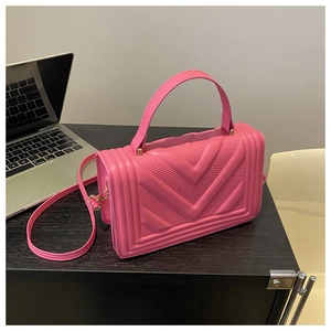 Dettaglio della borsa rosa con trama geometrica a V e fibbia in metallo dorato