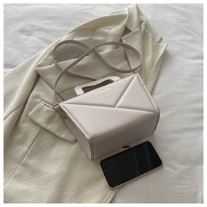 Detail of minimalist beige handbag with geometric stitching and gold Fashion logo