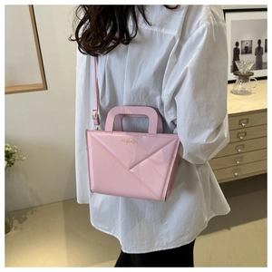 Pink geometric leather bag detail featuring gold FASHION embossing and folding texture