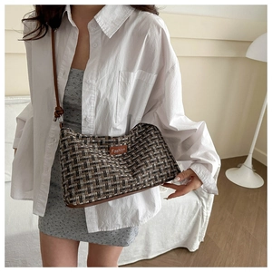Detail of vintage plaid tweed underarm bag featuring a brown leather fashion tag