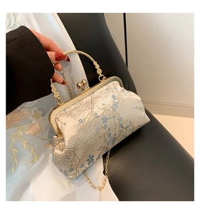 Close-up of floral embroidery and metallic ring handle on vintage qipao style handbag