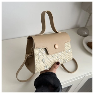 Détail du sac patchwork en paille et PU avec broderies florales blanches et anse