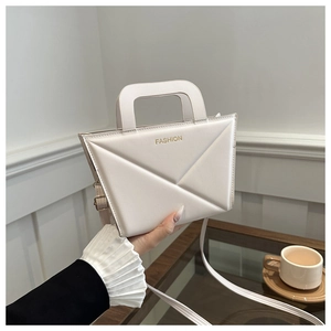 Detail view of cream structured crossbody bag with embossed lines and gold fashion lettering