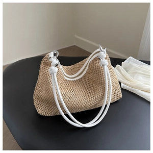 Nahaufnahme der Strohtasche mit weißen Seilgriffen und Metallring-Details