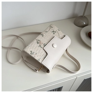 Vue détaillée du petit sac beige en mesh avec broderie florale et boucle métallique