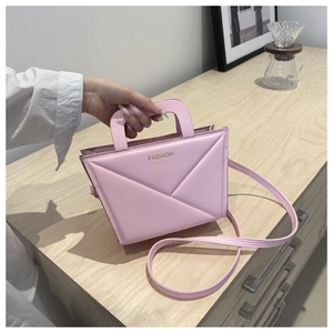 Detailed macro view of pink handbag with geometric quilted lines and golden FASHION text