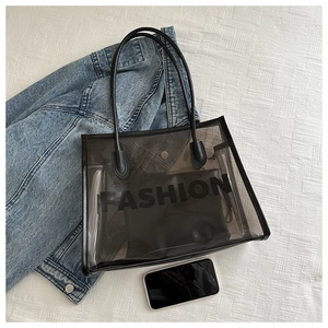 Detailed top view of black transparent jelly tote bag with FASHION print inner pouch