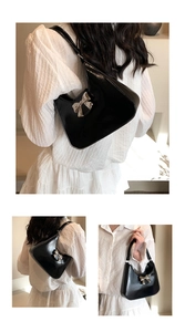 Detail view of black leather shoulder bag with silver bow ornament and slim strap